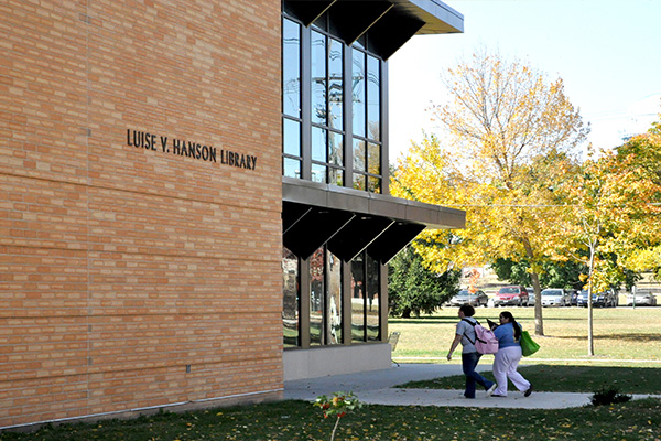 Two female students with backpacks walking into the Luise V. Hanson Library