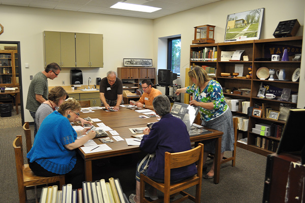 Various Waldorf alumni looking through archives in the Waldorf Library